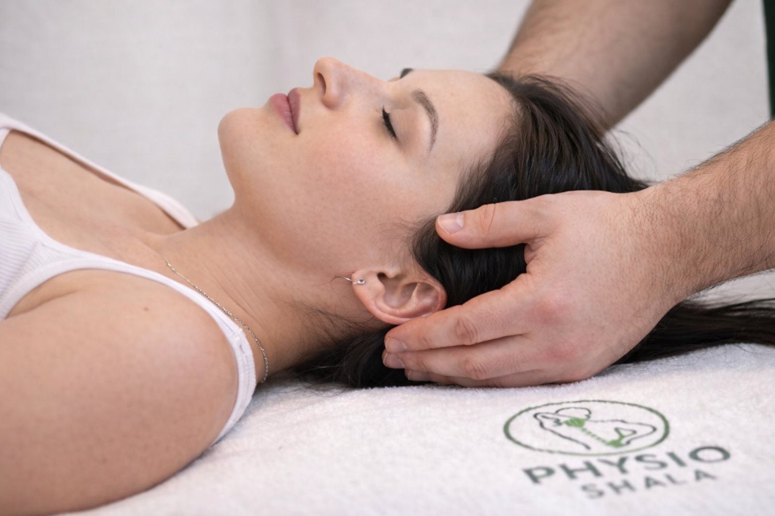 A woman receiving a head and scalp massage from a male therapists hands during a spa treatment session