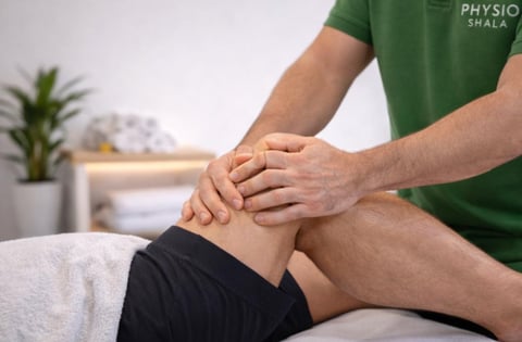 Physiotherapist in green shirt performing knee examination on patient lying on treatment table